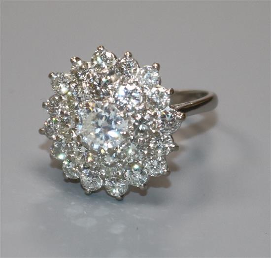 An 18ct white gold and diamond cluster ring, the central stone weighing approximately 0.90cts, size M.